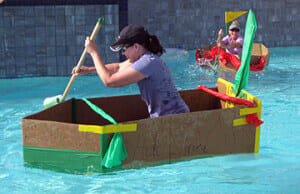 A partipant paddles her boat to victory during our Build a Boat team building activity