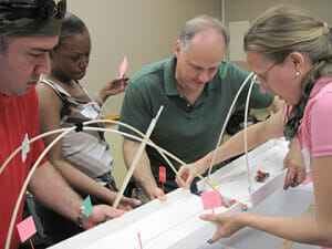 a team merges their bridge halves during our Build a Bridge team building activity