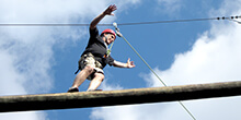 Participant gracefully balances during our ropes course team building activity in Orlando Florida