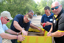 Teammates practice communication during our Build a Boat team building activity in Iowa