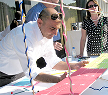 Partipant adds the final touches to their structure during Build a Bridge team building activity in Detroit Michigan
