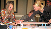 Colleagues adds a touch of flare to their creation during our Build a Bridge team building activity in Mississippi